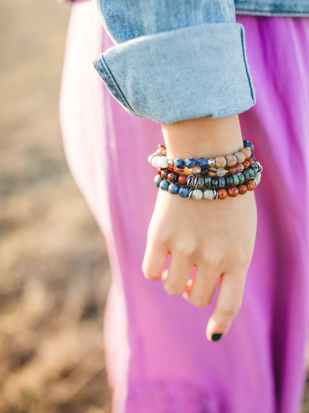 woman's wrist with multiple colorful bracelets on