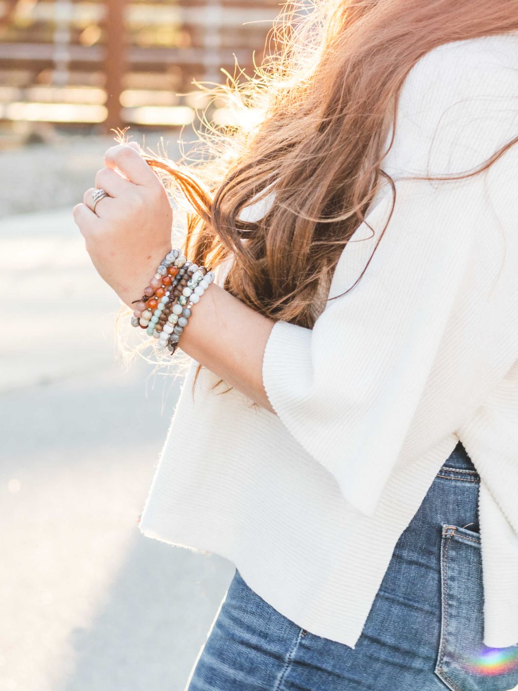 woman in white shirt with multiple bracelets on 